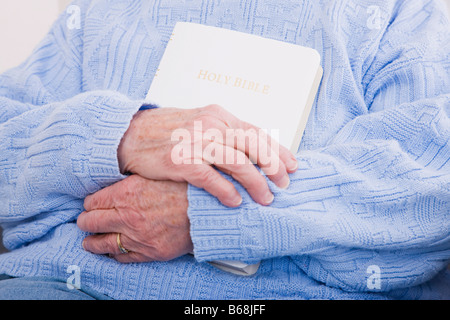 Senior woman holding Bible, mid section Banque D'Images