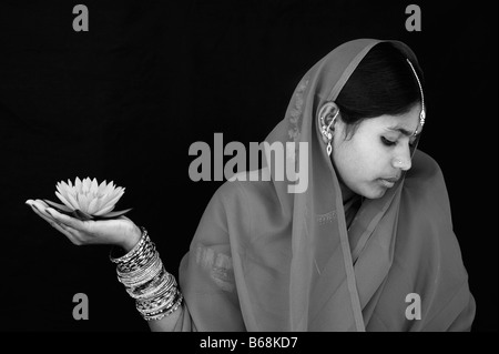 Femme indienne offrant un Nymphaea nénuphar Tropical flower dans un sari. Monochrome Banque D'Images