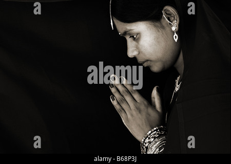 Femme en prière indienne. Sépia. L'Andhra Pradesh, Inde Banque D'Images