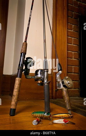 Cannes à pêche debout dans un coin avec de vieux leurres Banque D'Images