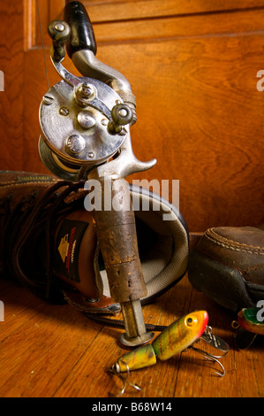 Une vieille canne et moulinet avec un leurre de pêche et porté des bottes de randonnée Banque D'Images