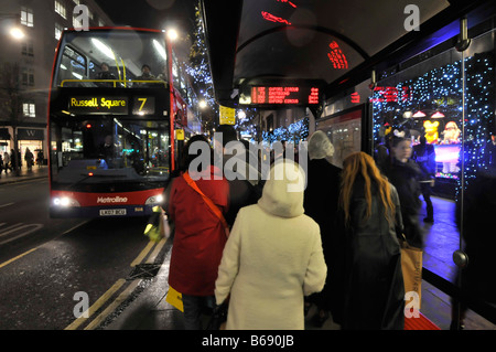 Arrêt de bus d'Oxford street et de bus avec chauffeur de bus horaires électroniques shoppers Noël Banque D'Images