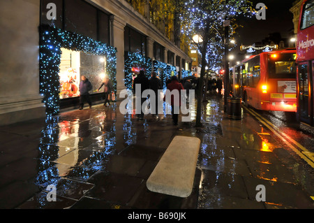 Jour de pluie à Londres Royaume-uni Oxford street avec les acheteurs de Noël et décorations de Noël à l'extérieur du grand magasin Selfridges West End juste cessé de pleuvoir Banque D'Images