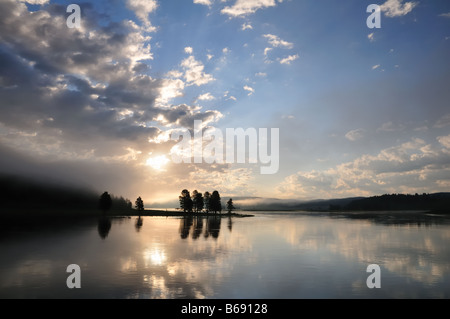 Grand soleil brille à travers les nuages dans la matinée sur une grande rivière Banque D'Images