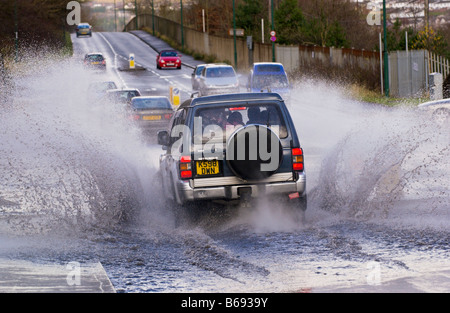 Les voitures roulent à travers l'eau d'inondation splash après road inondées par de fortes pluies Ebbw Vale South Wales UK Banque D'Images