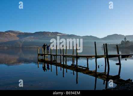 Homme et femme sur la jetée à Brandelhow, Derwent Water, Parc National de Lake District, Cumbria, Angleterre, Royaume-Uni Banque D'Images