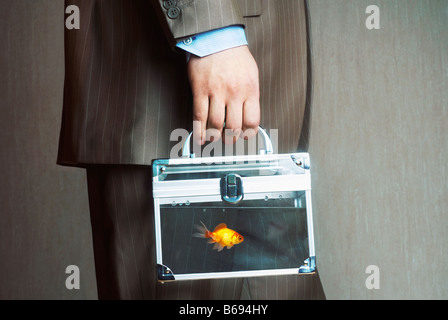 Man carrying case transparent rempli d'eau avec les poissons rouges, mid section Banque D'Images