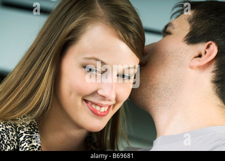 Homme murmurant à l'oreille de la femme, close-up Banque D'Images