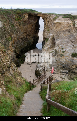 Longue série d'étapes menant jusqu'à une arche en pierre naturelle sur la côte de Cornouailles en Angleterre Banque D'Images