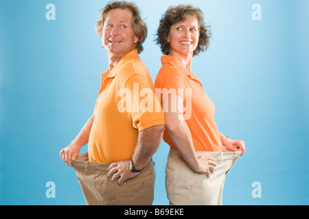 Homme et une femme de porter des pantalons pour montrer leur perte de poids Banque D'Images