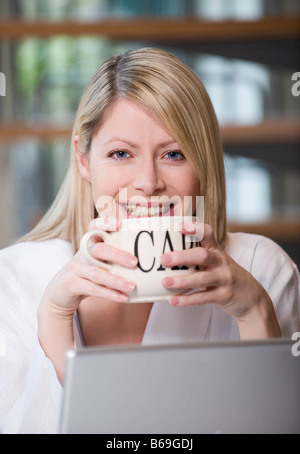 Les femmes ayant un cappuccino au travail Banque D'Images