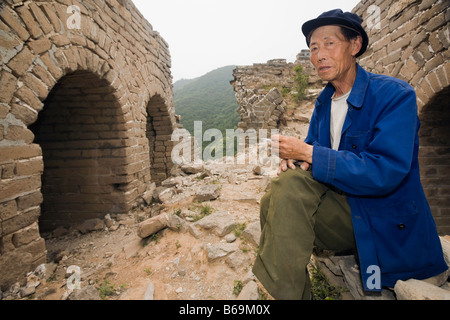 Portrait d'un homme assis sur un mur, et la Grande Muraille de Chine, Beijing, Chine Banque D'Images