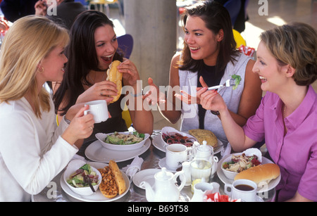 Quatre jeunes femmes prenant le déjeuner ensemble dans un café Banque D'Images