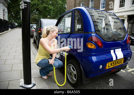 Jeune femme voiture électrique de charge Banque D'Images