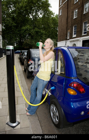Jeune femme à boire en voiture électrique
