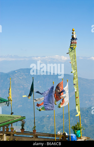 Les drapeaux de prières sur le toit d'une maison à Darjeeling, avec une vue sur les collines au loin Banque D'Images