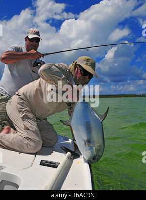 Un grand coup de permis l'heureux pêcheur est débarqué par le guide dans l'eau claire les appartements de Bimini aux Bahamas. Banque D'Images