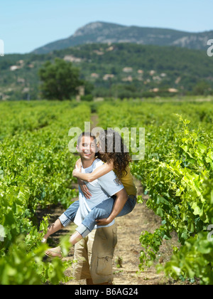 Man carrying woman in vineyard Banque D'Images