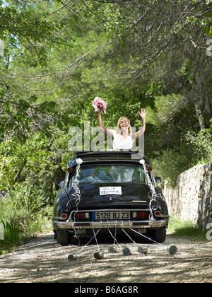 Voiture de mariage mariée waving from Banque D'Images