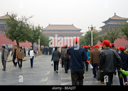 Chine Pékin un groupe de voyageurs chinois portant des bonnets rouges se dirige vers l'entrée de la Cité Interdite Banque D'Images