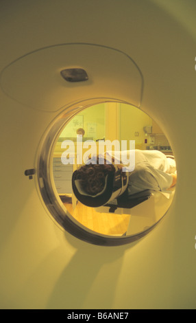 Dans patient CT scan avec support de tête dans la salle de commande visible technologue Banque D'Images