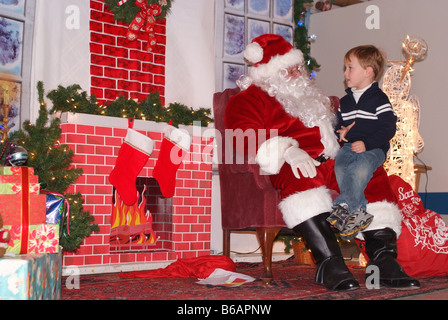 Des enfants assis sur les genoux du Père Noël Banque D'Images