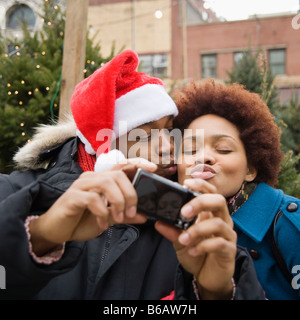 African man in santa hat taking self-portrait with girlfriend Banque D'Images