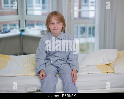 Patient assis sur le lit d'hôpital Banque D'Images