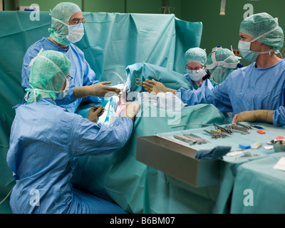 Chirurgiens performing operation in operating room Banque D'Images