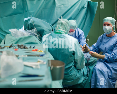 Chirurgiens performing operation in operating room Banque D'Images