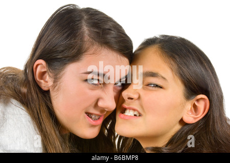 Close up portrait of horizontal de deux sœurs adolescentes grondant menaçant lors d'un combat contre un fond blanc Banque D'Images