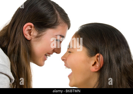 Close up portrait of horizontal de deux sœurs adolescentes dans le rire hystérique sur un fond blanc. Banque D'Images