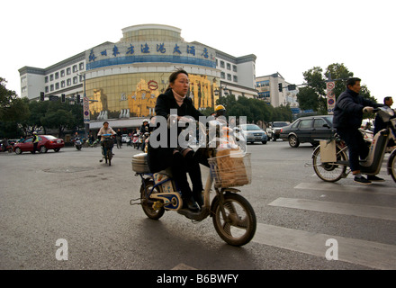 Une foule chaotique des navetteurs sur les ressources ordinaires et les vélos électriques pendant les heures de pointe du matin à une intersection Banque D'Images