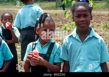Sur une pause de leur école située à côté de la réserve communautaire des babouins, les filles dans leurs uniformes scolaires profiter shaved ice. Banque D'Images