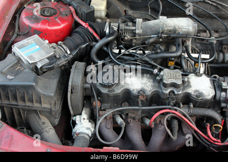 Sous le capot un moteur de voiture sale vieille de vingt ans une vieille vauxhall cavalier dans le besoin d'entretien Banque D'Images