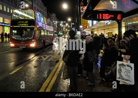 Arrêt de bus d'Oxford street et de bus avec chauffeur de bus horaires électroniques shoppers Noël Banque D'Images