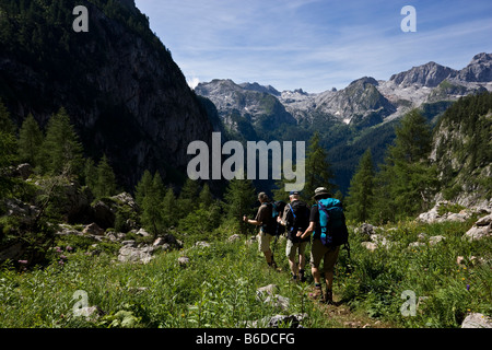 Groupe de randonneurs marchant vers le bas sur l'étroit sentier près de Koenigssee Alpes de Berchtesgaden Allemagne Août 2008 Banque D'Images