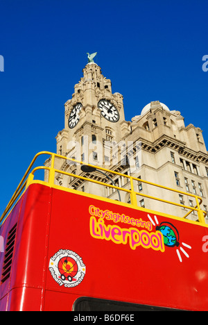 Red open top bus touristique en face de l'assurance Royal Liver Building situé à Pier Head à Liverpool Banque D'Images