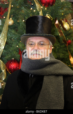 Un homme vêtu de l'époque victorienne en face d'un arbre de Noël Banque D'Images