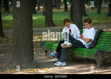 La Russie, Saint-Pétersbourg, jardin d'été (Letnij Sad ). Jeune couple avec les téléphones mobiles. Banque D'Images