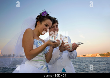 La Russie, Saint-Pétersbourg, des couples de célébrer leur mariage avec un pigeon blanc à la frontière de la rivière Néva Banque D'Images