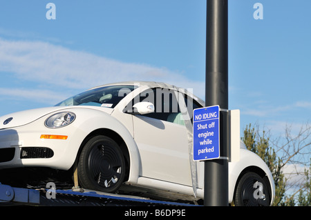 VW Coccinelle sur le transport de voiture garée à côté de l'opérateur de signer 'non au ralenti, arrêter le moteur en stationnement". USA Banque D'Images