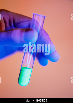 Tube à essai contenant un solide, c'est chimique fluorescent vert brillant Banque D'Images