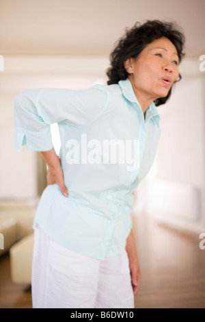 Woman holding her, bas du dos douloureux backpain est une plainte qui touche le plus souvent soutien lombaire Banque D'Images