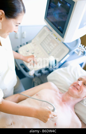 L'échocardiographie. Senior patient l'objet d'une échographie cardiaque. Un capteur,maintenu contre sa poitrine. Banque D'Images