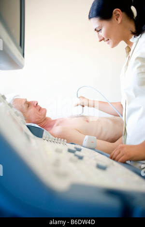 L'échocardiographie. Senior patient l'objet d'une échographie cardiaque. Un capteur,maintenu contre sa poitrine. Banque D'Images