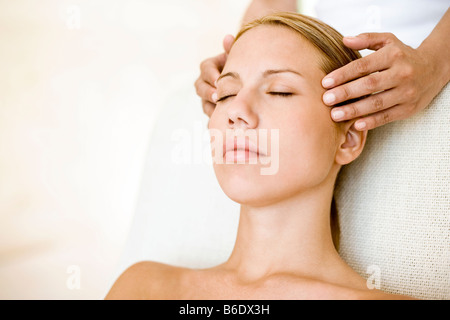 Woman receiving massage du temple qui peut soulager la douleur ou raideur musculaire en stimulant le flux sanguin à la zone affectée Banque D'Images