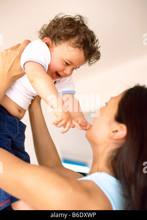 Bébé garçon et la mère.9-month-old baby boy toucher le visage de sa mère comme elle lève sa tête sur lui. Banque D'Images