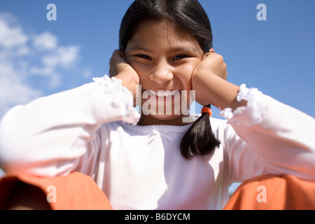 Happy girl posant sa tête sur ses mains. Banque D'Images