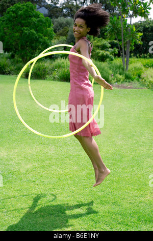 Femme jouant avec un cerceau dans un jardin. Banque D'Images